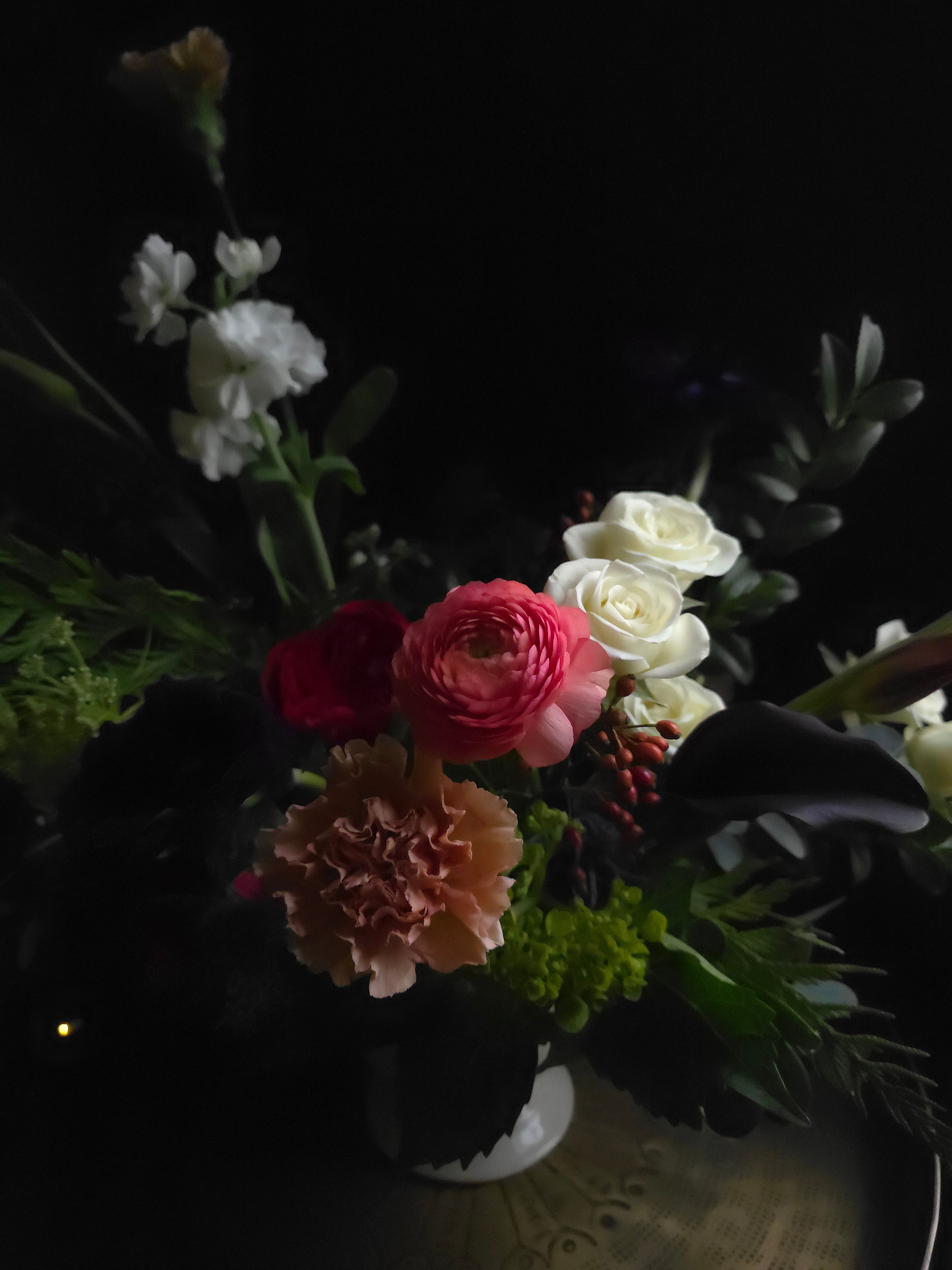 Bouquet of flowers with white, pink, and red colors against a dark background