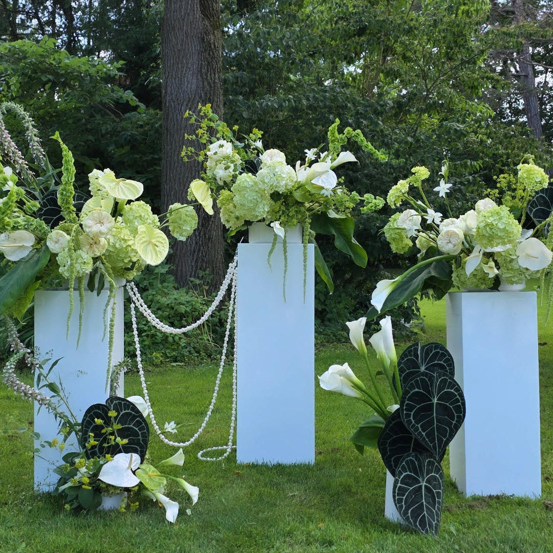 Contemporary wedding ceremony flowers in green and white tones with sculptural floral design