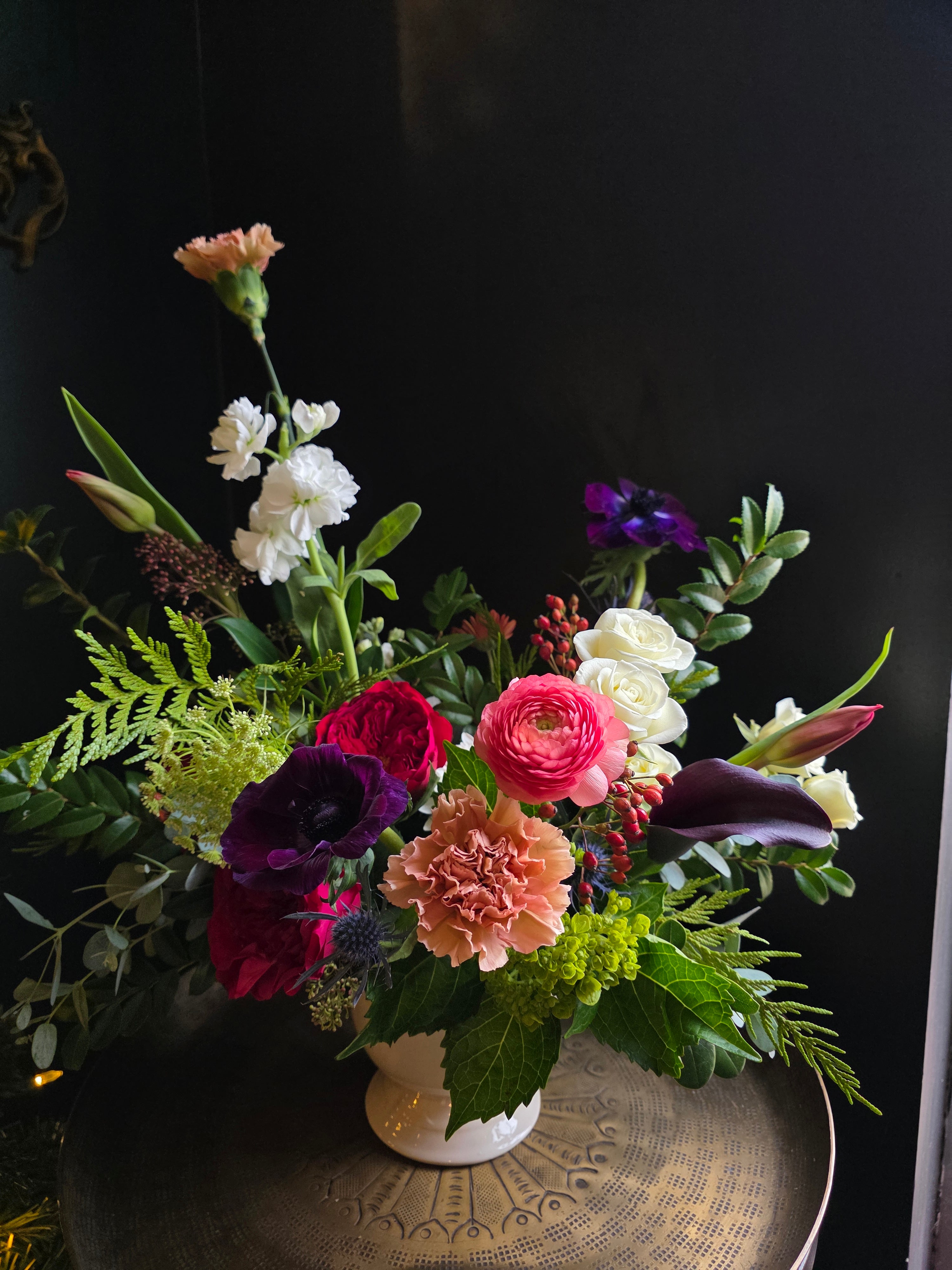 Colorful flower arrangement in a vase against a dark background