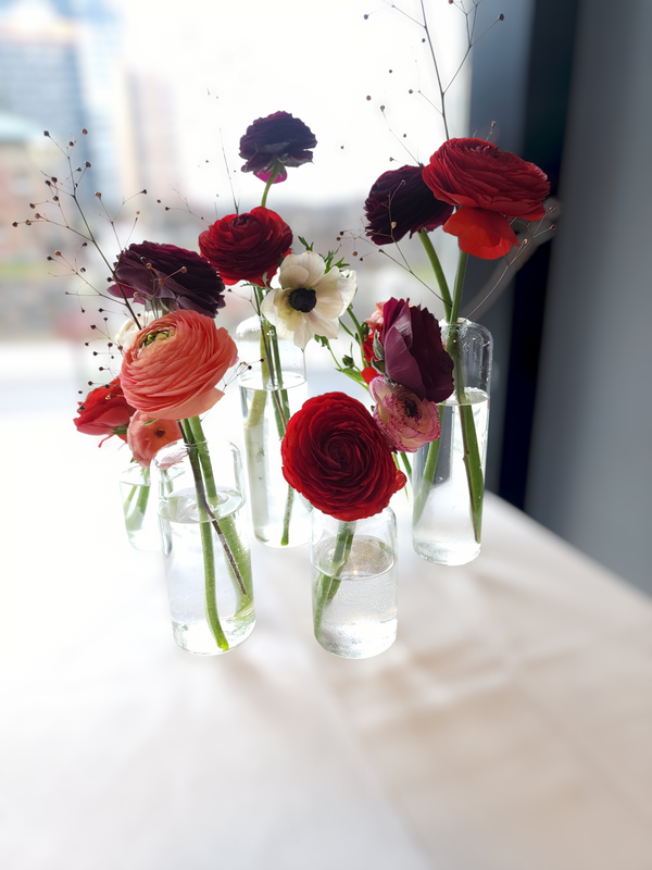 colourful ranunculus and anemone in glass budvase
